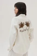 Blazer de lino color blanco con bordados en tonos marrón dorado y plateado, al frente y en la espalda.