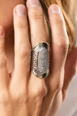 Anillo plateado con forma ovalada y superficie texturizada, con apliques de zirconias blancas y detalles en dublé de oro.