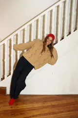 Buzo tejido color beige con cuello alto y bordado a mano con lana roja.