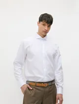 Camisa de vestir blanca de manga larga, con cuello clásico y cierre frontal de botones.