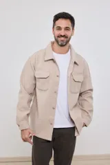 Sobrecamisa de tejido grueso sin forro, con diseño de corte holgado y silueta cuadrada. Presenta cuello clásico, cierre frontal con botones mate y dos bolsillos en el pecho con solapa.