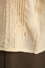 Blusa de algodón peinado color negro, con tirantes finos, escote en V y detalles de bordados y encaje en el frente.