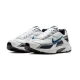 Championes de running Nike modelo Initiator, con diseño técnico en colores blanco, gris y detalles en azul oscuro. Presentan una estructura de malla transpirable con refuerzos sintéticos, entresuela amortiguada y suela de goma resistente.