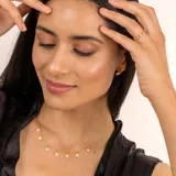 Collar dorado con cadena fina y dijes colgantes de estrellas con incrustaciones de topacio blanco.