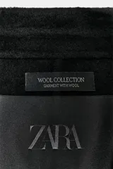 Blazer Zara de corte entallado confeccionada en mezcla de lana. Presenta cuello con solapa de muesca, manga larga y cierre frontal con un solo botón.