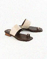 Sandalias de cuero color marrón con suela plana y taco bajo de madera. Tienen una tira ancha en el empeine con textura de reptil en tono crudo y un separador de dedos con aplique metálico dorado. El borde de la suela está decorado con pequeños tachas doradas.