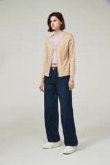 Cárdigan color beige con escote en V y cierre frontal con botones.