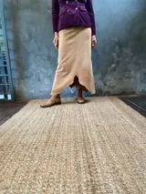 Pollera larga color beige de gamuza, con cierre lateral y ruedo irregular.