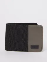 Billetera plegable Rusty con diseño bicolor, combinando una sección texturizada en color negro con una sección lisa en color gris. Incluye una placa metálica con el logo de la marca en la parte frontal.