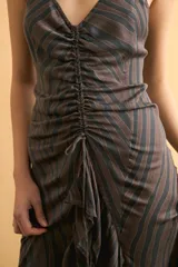 Vestido midi marrón con rayas y efecto lavado, escote en V, tirantes finos y frunce central ajustable con cordón en el delantero.