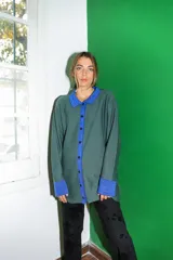 Saco tejido a máquina con rayas verticales negras y marrones, cuello camisero y botones rojos.