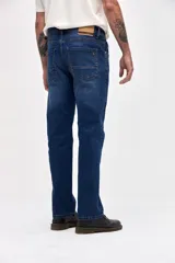 Jean de corte slim, ajustado desde la cadera hasta los tobillos, en color azul oscuro con costuras en contraste.