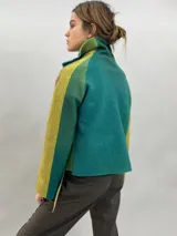 Chaqueta de lana merino afieltrada con diseño en degradé de tonos verdes y amarillos. Presenta un corte recto, cuello alto, mangas largas y bolsillos laterales.