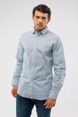 Camisa de manga larga con diseño de cuadros en tonos azules, blancos y negros. Presenta cuello clásico, cierre frontal con botones y logo bordado en el pecho. Corte semi slim.