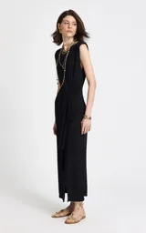 Vestido midi de tejido de punto color negro, con escote redondo, sisas amplias sin mangas, lazo frontal en la cintura y falda recta con abertura frontal.