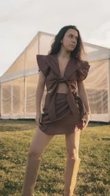 Falda corta tipo pareo confeccionada en lino color marrón, con diseño envolvente y lazo lateral ajustable para un calce cómodo.