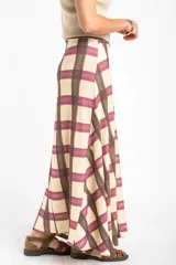 Falda maxi con estampa a cuadros en tonos beige, bordó y marrón, de corte largo y fluido.