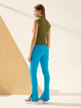 Calza verde oliva de punto acanalado con cintura elastizada y tajos laterales en el ruedo.