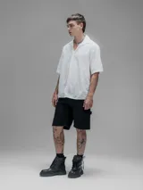 Camisa blanca de manga corta, con cuello abierto y calce oversize. Confeccionada en algodón bordado tipo broderie con diseño floral.