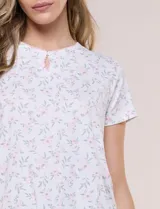 Conjunto pijama de remera de manga corta y pantalón capri blanco con delicado estampado floral en tonos rosados y verdes, confeccionado en tejido acanalado fino con escote redondo y detalle de gota con botón.