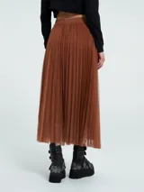 Falda midi de corte acampanado confeccionada en capas de tul plisado, con cintura elástica y detalle de encaje en el ruedo.