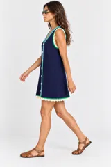 Vestido corto azul marino de tejido abierto, con escote en V, cierre frontal de botones y detalles de ribetes en celeste y verde, con terminaciones en encaje crudo.