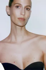 Body negro con escote corazón y tirantes finos ajustables. Presenta un sutil patrón de tejido en relieve vertical y detalle de entredós a tono en el cuerpo. Cierre inferior con botones a presión.