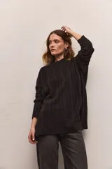 Buzo tejido de algodón color negro, con cuello redondo, diseño de ochos verticales y corte ancho.