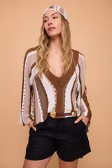 Sweater tejido a crochet con rayas horizontales en tonos marrón, beige y blanco. Tiene escote en V y mangas largas acampanadas.