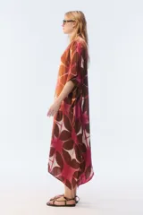 Kaftan maxi amplio de color amarillo, con escote redondo, mangas cortas y ruedo irregular. Presenta un diseño estampado a cuadros con efecto teñido.