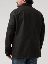 Chaqueta de estilo clásico confeccionada en tela encerada impermeable, con cuello de cotelé, cierre frontal con botones y bolsillos delanteros con solapa.