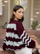 Campera de tejido de punto con cierre frontal doble, presentando un patrón de ondas en colores azul marino y crudo.