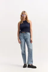 Top corto de algodón color azul marino, de corte ajustado al cuerpo y diseño sin mangas con escote redondo. Presenta textura fruncida tipo smock en todo el torso y un delicado volado en el ruedo.