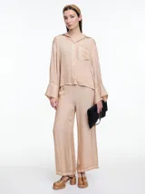 Pantalon de corte amplio y relajado, confeccionado en viscosa con acabado satinado y efecto lavado. Presenta cintura elastizada y detalles de desgaste en costuras y ruedo.