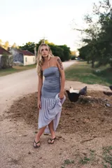 Vestido midi con diseño de dos piezas simuladas, cuerpo superior ajustado tipo strapless en lycra y falda inferior fluida en gasa con caída asimétrica.