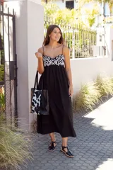 Sandalias de cuero negro con diseño de tiras entrecruzadas, hebilla dorada y suela plana.