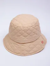 Gorro tipo bucket color beige con diseño acolchado de rombos y pequeño logo circular en el lateral.