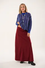 Falda larga color borgoña, confeccionada en tela suave con acabado tipo piel de durazno y cierre invisible lateral.