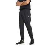 Pantalón deportivo New Balance de corte jogger, color negro, con cintura elástica ajustable mediante cordón, puños elásticos en los tobillos y logo de la marca bordado en la pierna izquierda.