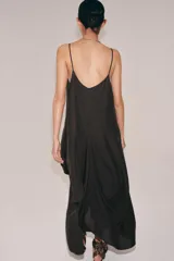 Vestido midi de tirantes finos con escote redondo, confeccionado en mezcla de viscosa y lino. Presenta un diseño con volumen, detalle de pliegues frontales y bajo asimétrico.