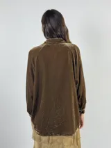 Camisa verde oscuro de terciopelo de viscosa, con cuello mao, corte recto, mangas largas abullonadas y cierre frontal con botones.