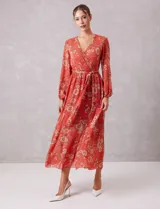 Vestido midi de gasa estampada con diseño floral, escote en V cruzado, cintura elastizada con lazo de ajuste y mangas largas con puños fruncidos. Incluye forro interno a tono.