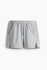 Short deportivo gris de tejido funcional con tecnología DryMove™ que absorbe el sudor. Diseño a media pierna con stretch en cuatro direcciones, cintura elástica con cordón ajustable oculto, bolsillos al bies, detalle reflectante en la parte posterior y aberturas laterales cortas en el bajo. Corte estándar.