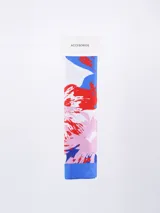 Pañuelo rectangular de tela suave con estampado abstracto en tonos azul, rojo y rosado sobre fondo blanco, con borde inferior en color azul sólido.