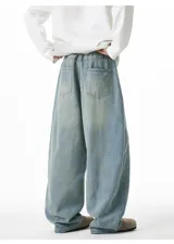 Pantalón de jean azul claro lavado, de corte muy amplio y holgado (baggy fit), con cintura elástica y bolsillos delanteros y traseros.