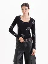 Remera de algodón negro con estampado de fresas y alfileres de gancho, de manga larga y escote redondo amplio.