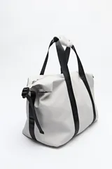 Bolso tipo duffel negro de símil cuero con cierre superior de cremallera metálica y asas reforzadas.