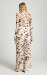 Pantalón de tul Le Lis Blanc modelo Marfim, de pierna ancha y corte fluido, con estampado abstracto en tonos beige y marrón. Cuenta con cinturilla drapeada en la parte delantera y forro interior corto.