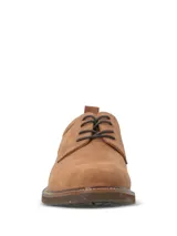Zapato de vestir tipo derby marca Hush Puppies, confeccionado en cuero gamuzado color tostado. Presenta cordones oscuros, costuras reforzadas y suela de goma con efecto moteado.