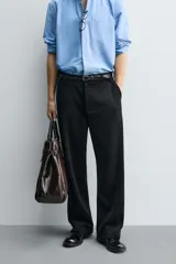 Pantalón de corte wide fit confeccionado en pana de algodón color marrón oscuro. Presenta bolsillos frontales, bolsillos traseros de vivo con botón y cierre frontal con cremallera y botón.